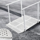 White metal wheelchair ramp on a textured surface