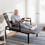 Elderly man reading while seated comfortably on the electric adjustable floor bed in reclined position.