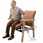 Senior using brown leather power lift chair with wooden arms for assisted standing